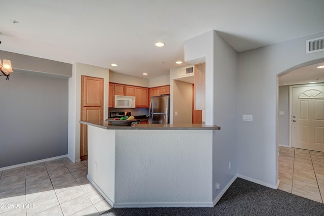 kitchen with stainless steel appliances, light tile patterned floors, and kitchen peninsula