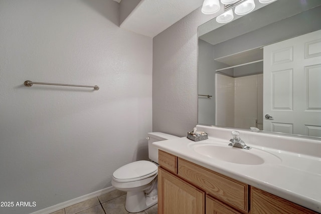 bathroom featuring vanity, a shower, tile patterned floors, and toilet