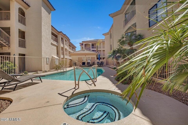 view of swimming pool with a patio area and a community hot tub