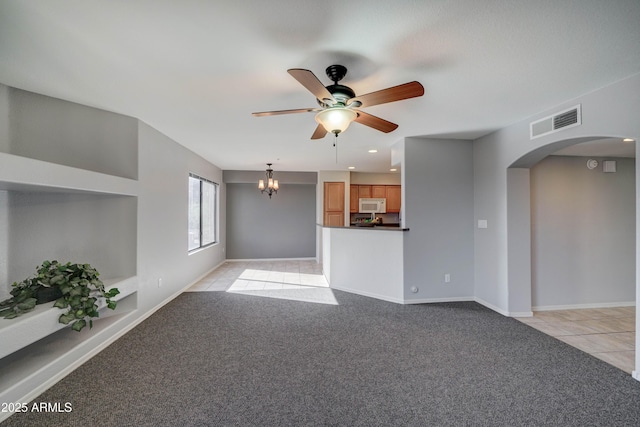 unfurnished living room featuring ceiling fan with notable chandelier and light carpet
