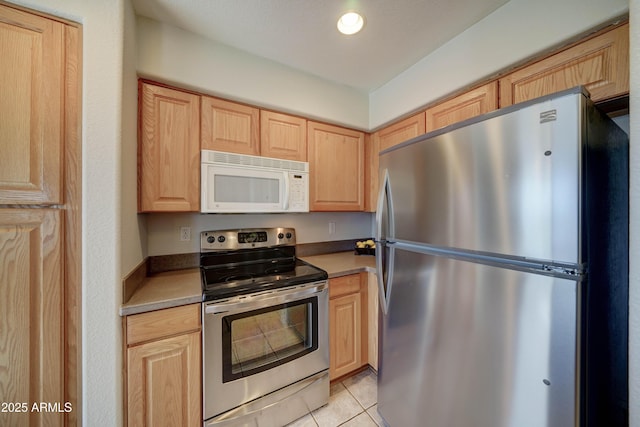 kitchen featuring appliances with stainless steel finishes, light brown cabinets, and light tile patterned floors