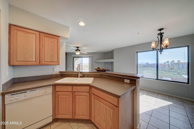 kitchen featuring pendant lighting, sink, white dishwasher, light tile patterned flooring, and kitchen peninsula