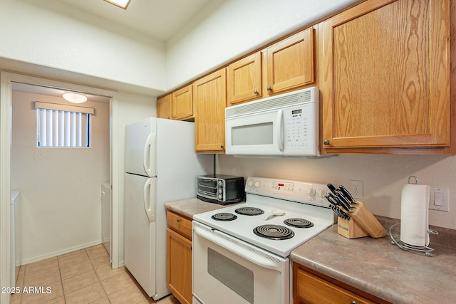 kitchen with light tile patterned flooring, a toaster, white appliances, baseboards, and light countertops