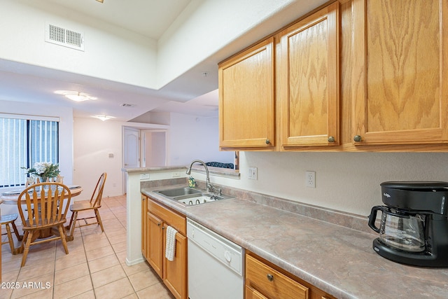 kitchen featuring light countertops, visible vents, light tile patterned flooring, white dishwasher, and a sink