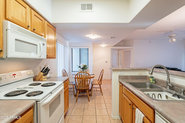 kitchen with light tile patterned floors, white appliances, a sink, and visible vents