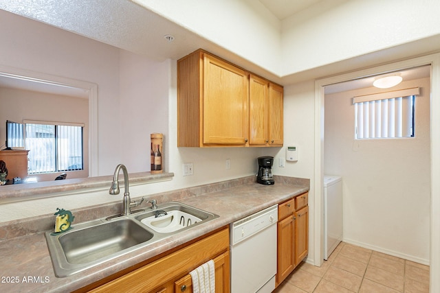 kitchen with baseboards, dishwasher, light countertops, a sink, and light tile patterned flooring