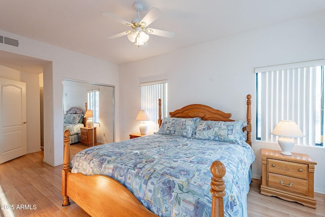 bedroom featuring ceiling fan, light wood finished floors, a closet, and visible vents