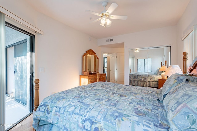 bedroom with access to exterior, a closet, visible vents, ceiling fan, and wood finished floors