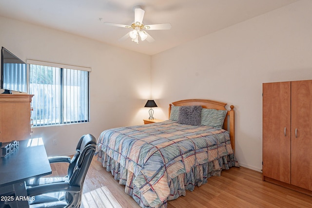 bedroom featuring light wood finished floors, a ceiling fan, and baseboards