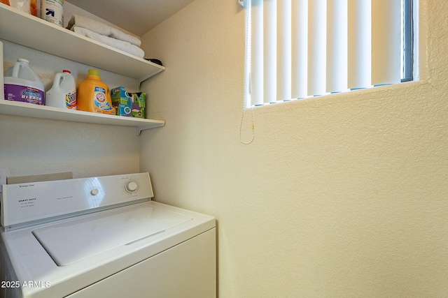 laundry area with washer / dryer and a textured wall