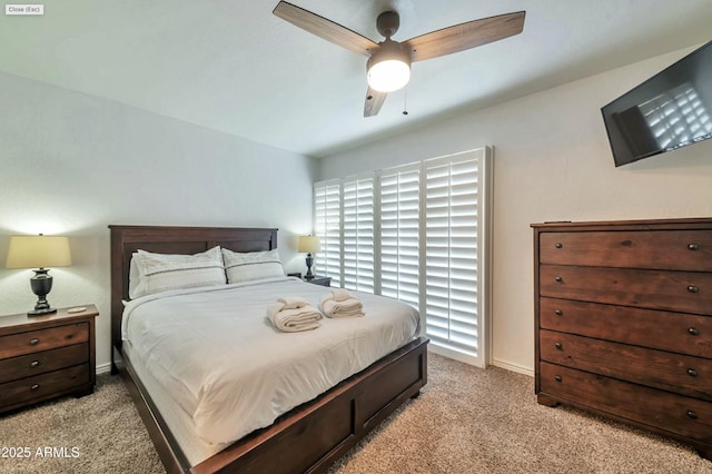 bedroom featuring light carpet, a ceiling fan, and baseboards