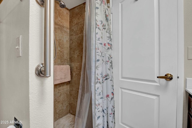 bathroom with a shower stall and vanity