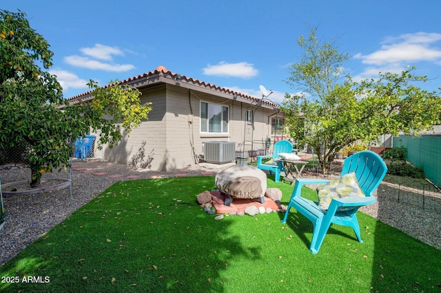 view of yard with central AC and fence