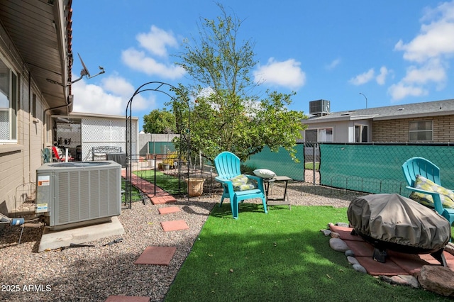 view of yard featuring central AC and fence