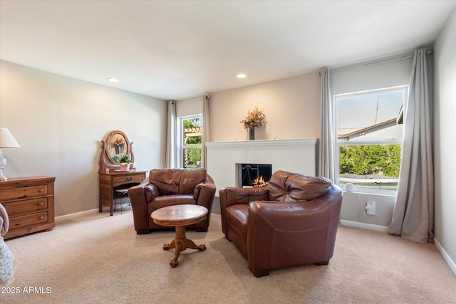 living area featuring carpet flooring, recessed lighting, baseboards, and a warm lit fireplace