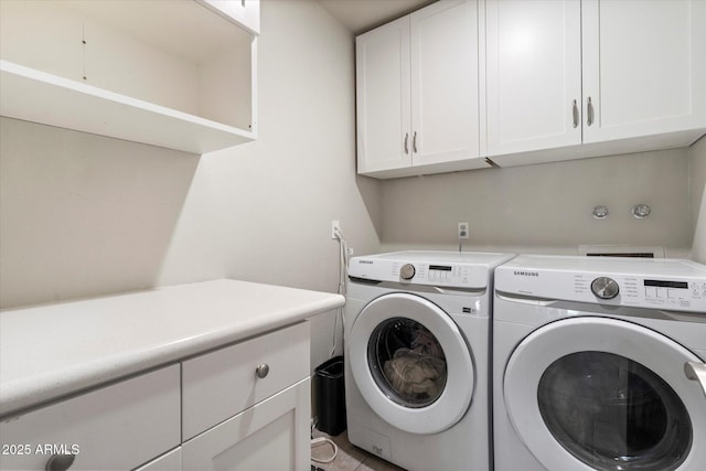 washroom with washer and dryer and cabinet space