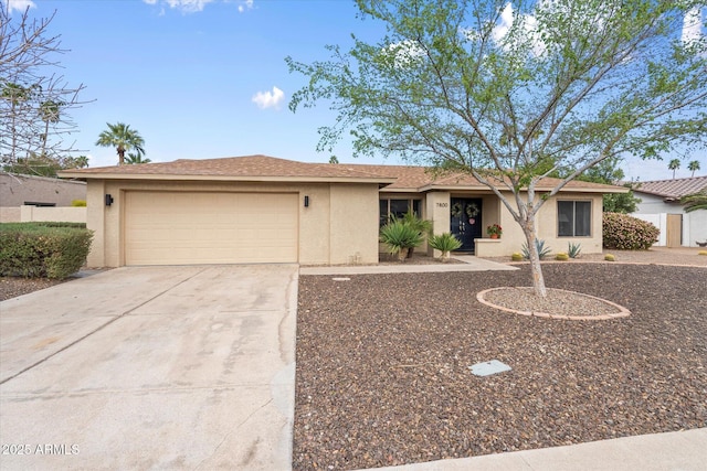 ranch-style home featuring stucco siding, concrete driveway, and an attached garage