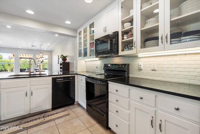 kitchen with decorative backsplash, black appliances, dark countertops, and a sink