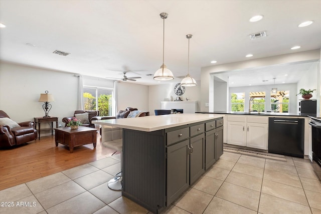 kitchen featuring light tile patterned floors, visible vents, black dishwasher, and open floor plan