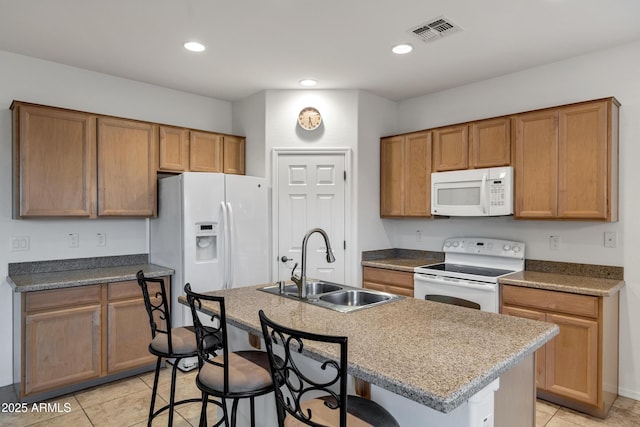 42335 W Waterfall Way, Maricopa, AZ 85138 - kitchen with light tile patterned floors, white appliances, a kitchen breakfast bar, visible vents, and a sink