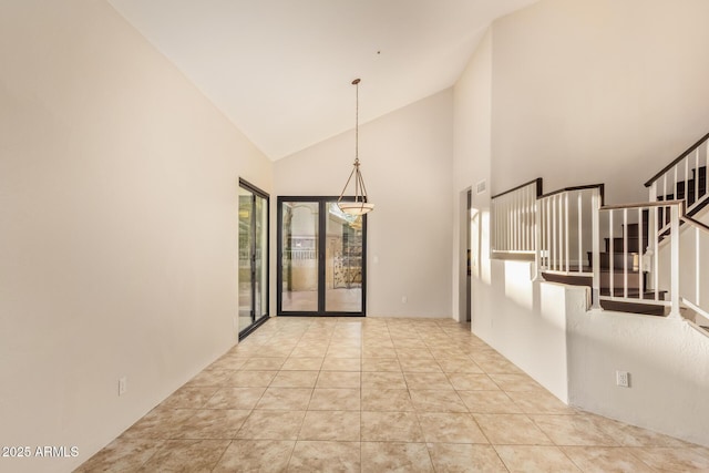 empty room with stairs, high vaulted ceiling, and light tile patterned flooring