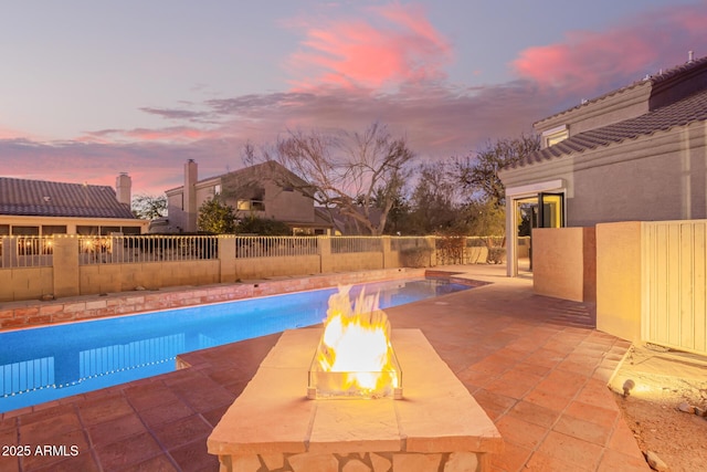 view of pool with a fire pit, a fenced in pool, and a patio