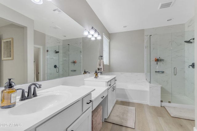 bathroom with hardwood / wood-style floors, vanity, and separate shower and tub