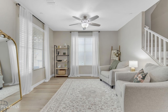 living room featuring ceiling fan and light hardwood / wood-style flooring