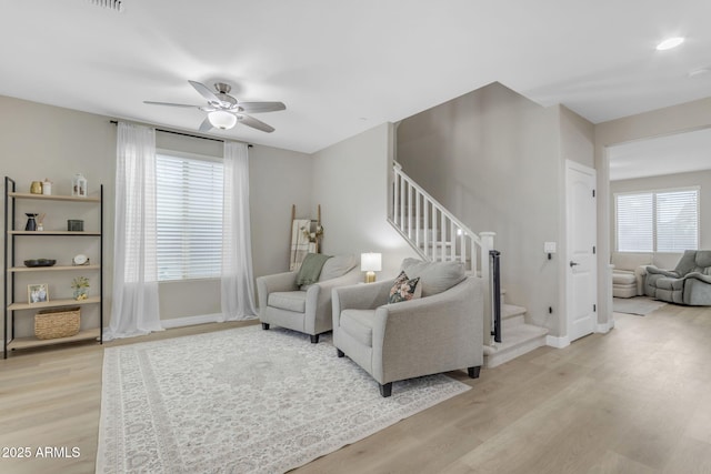 living room featuring plenty of natural light, light hardwood / wood-style floors, and ceiling fan