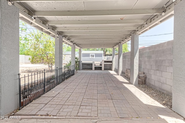 view of patio with a storage unit, a fenced backyard, and an outbuilding
