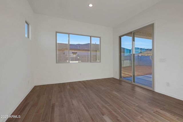 spare room featuring plenty of natural light and hardwood / wood-style floors