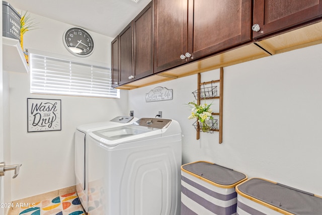 laundry room with cabinets, light tile patterned floors, and washing machine and dryer