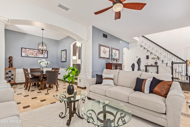 living room featuring ceiling fan with notable chandelier and decorative columns