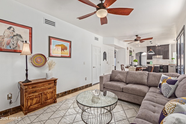 tiled living room with ceiling fan