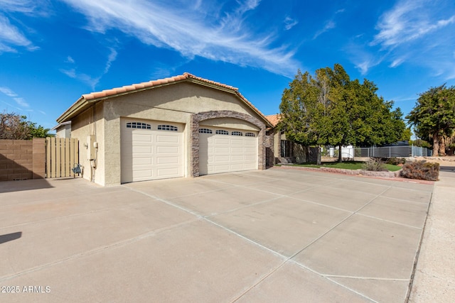 garage with driveway and fence