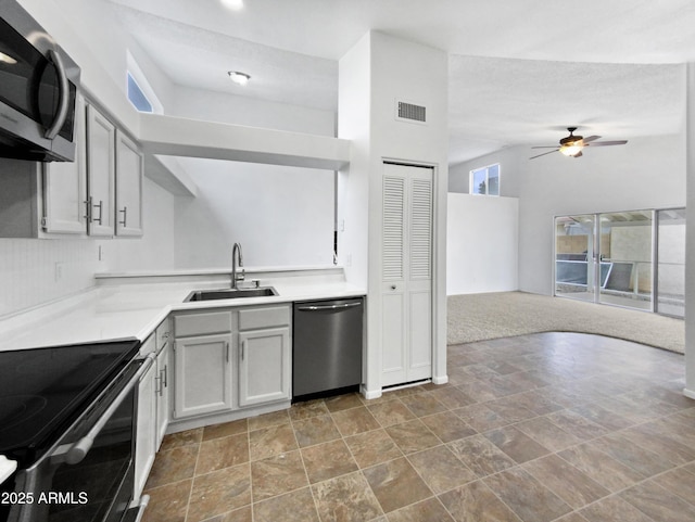 kitchen with visible vents, open floor plan, stainless steel appliances, light countertops, and a sink