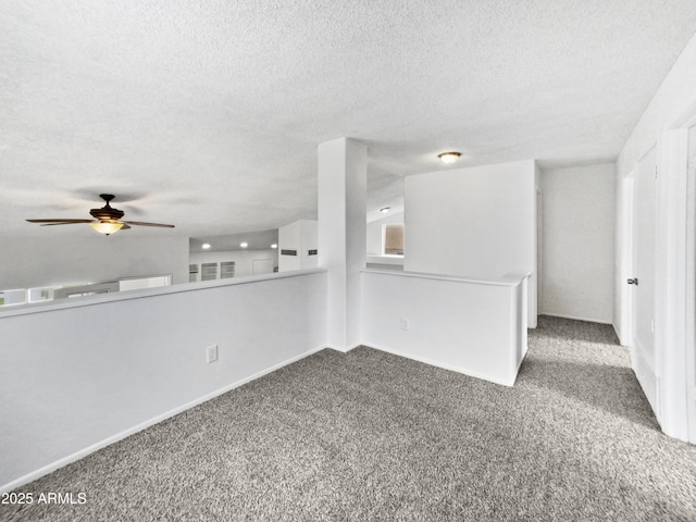 carpeted empty room with a ceiling fan and a textured ceiling