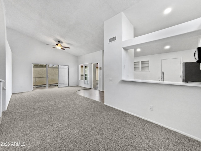 unfurnished living room featuring a textured ceiling, high vaulted ceiling, carpet floors, visible vents, and a ceiling fan