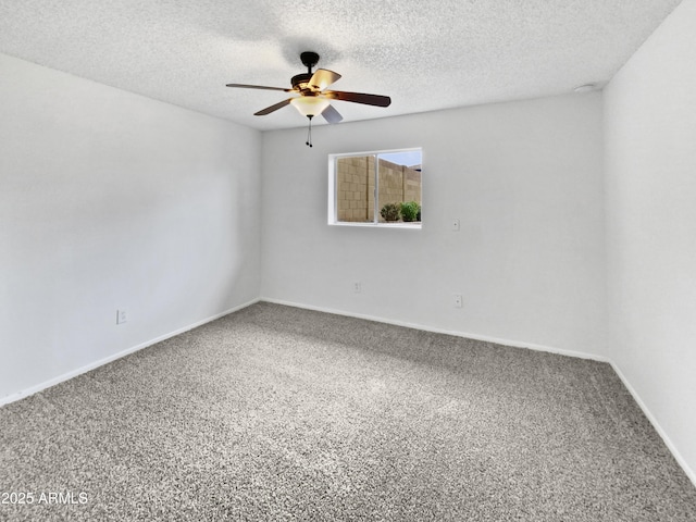 carpeted spare room featuring ceiling fan, a textured ceiling, and baseboards