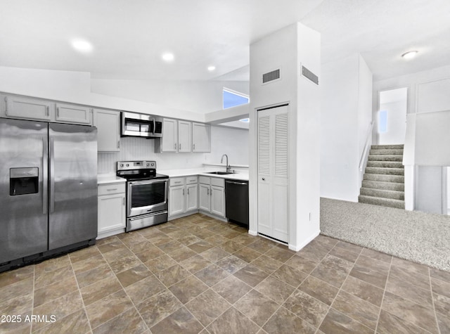 kitchen featuring a sink, stainless steel appliances, light countertops, and gray cabinetry