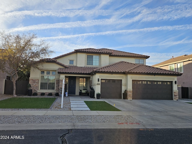 mediterranean / spanish house featuring an attached garage, concrete driveway, and stucco siding