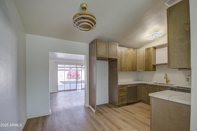 kitchen featuring light stone countertops, sink, vaulted ceiling, appliances with stainless steel finishes, and light wood-type flooring