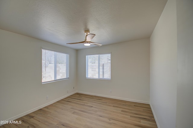 spare room with ceiling fan, light wood-type flooring, and a textured ceiling