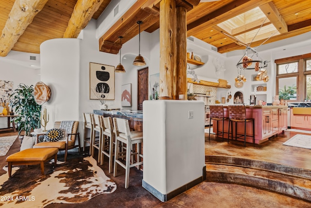 kitchen featuring beamed ceiling, a breakfast bar, wood ceiling, and hanging light fixtures