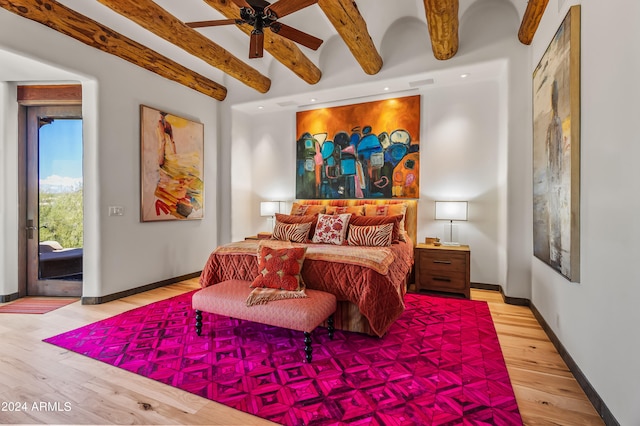 bedroom with ceiling fan, beamed ceiling, and hardwood / wood-style floors