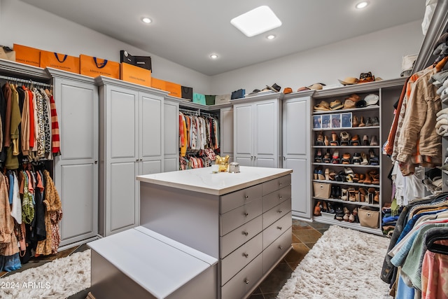 walk in closet with dark tile patterned flooring