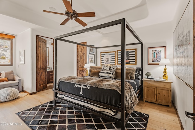 bedroom featuring ensuite bath, light wood-type flooring, and ceiling fan