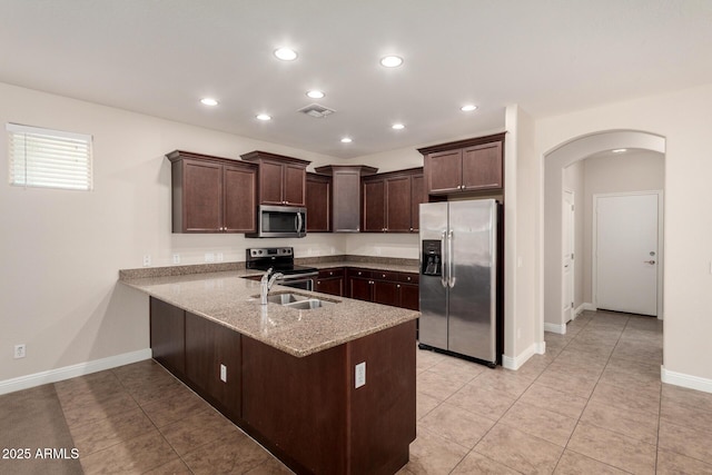 3449 E Sheffield Rd, Gilbert, AZ 85296 - kitchen with appliances with stainless steel finishes, a sink, arched walkways, a peninsula, and dark brown cabinets