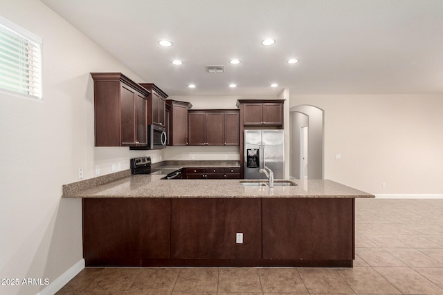 3449 E Sheffield Rd, Gilbert, AZ 85296 - kitchen with stainless steel appliances, a sink, arched walkways, dark brown cabinetry, and recessed lighting