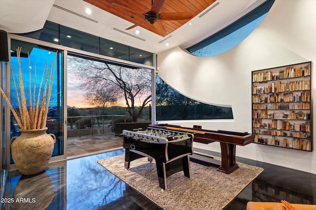 rec room with ceiling fan and floor to ceiling windows